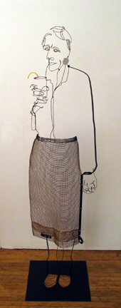 Figurative wire sculpture of standing woman with drink in hand